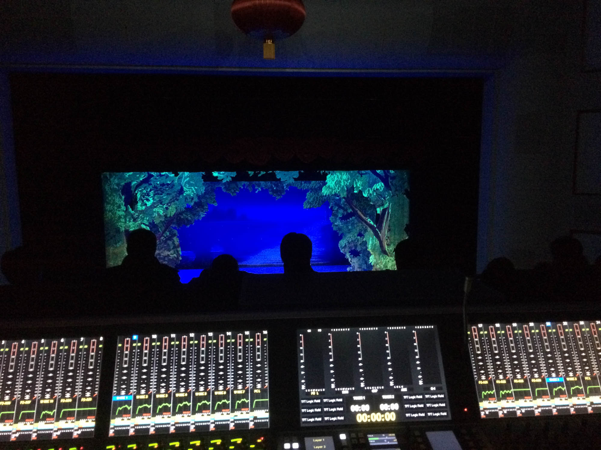Theatre control position with monitors facing a lit stage