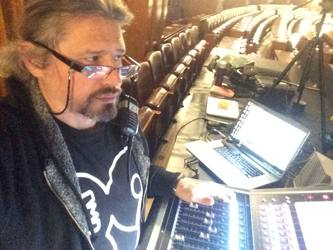 Audio engineer operating a console in a theatre venue